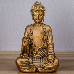 Cette statue représente un Bouddha de couleur or en position de méditation.